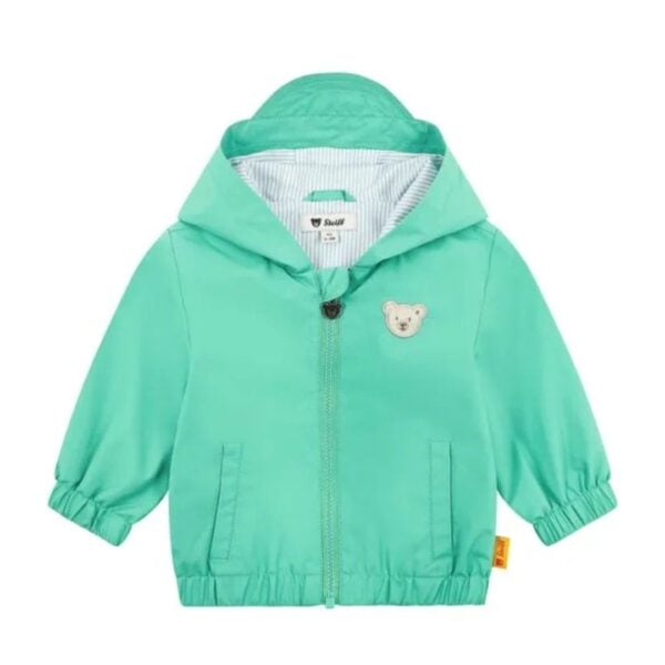 This lightweight rain jacket in fresh green is the perfect shield for little adventurers on rainy days. The hood, featuring a small visor, keeps them reliably dry, while the blue and white striped lining adds a cheerful splash of colour. Soft, elasticated trims at the hem and cuffs ensure a cosy fit, allowing plenty of freedom to move. The zip, complete with a cute Teddy bear detail and chin guard, and two practical pockets offer room for little treasures. The water-repellent, breathable BIONIC-FINISH®ECO finish and the cuddly Steiff Teddy bear motif make this jacket an ideal companion for every adventure.
