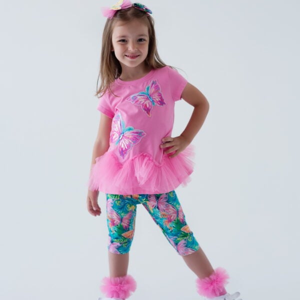 Daga - More Sugar 2025 Summer Collection - 2 piece Tunic & capri leggings set of gorgeous loose fitting stretchy jersey tunic with all over Exclusive Daga More sugar Lollipop print and two applique Lollipops with diamante and tulle bows, ruffle sleeves and triple ruffle hi low hem. Soft stretchy jersey leggings in fucsia pink which have a More Sugar Lollipop print with tulle bow on each leg - elasticated waistband. Easy to wear - a very pretty set.