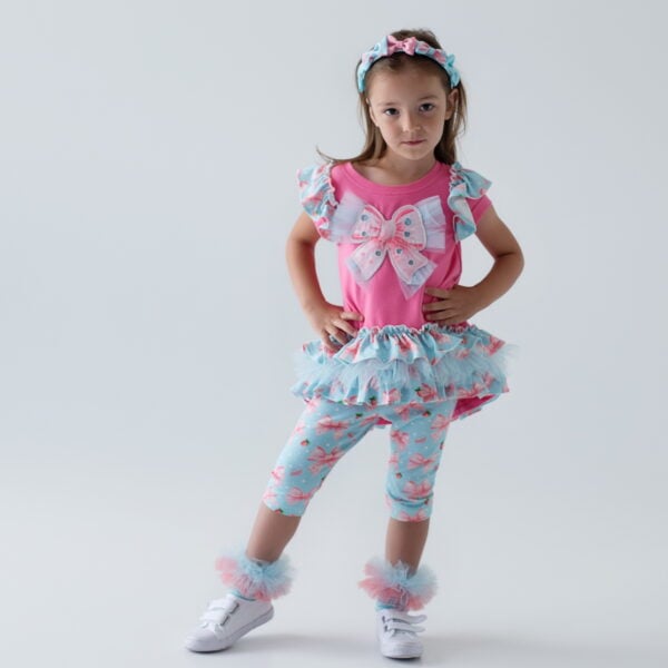 Daga - Magic Bow 2025 Summer Collection - 2 piece Tunic & capri leggings set of gorgeous loose fitting stretchy jersey tunic with ruffle shoulders and triple ruffle hi low hem - with extra large Daga Magic Bow applique with soft tulle on the front, and loose fitting body. Soft stretchy jersey leggings which have an all over Magic Bow print - and elasticated waistband. Easy to wear - a very pretty set.