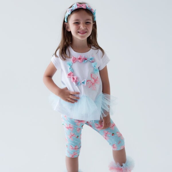 Daga - Magic Bow 2025 Summer Collection - 2 piece Tunic & capri leggings set of gorgeous loose fitting stretchy jersey tunic with applique Daga Magic Bow on the front with different colours of fixed bows, cap sleeves and soft tulle ruffles around the waist. Soft stretchy jersey leggings with an all over Exclusive Daga Magic Bow print - elasticated waistband. Easy to wear - a very pretty set.