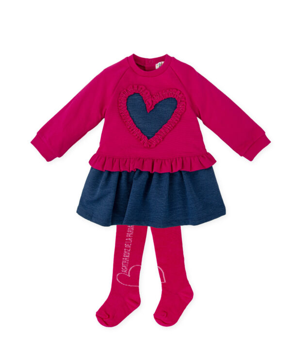 Pink and blue dress set for girls by Agatha Ruiz de la Prada, made in soft cotton-blend jersey. Cosy and comfortable, the long-sleeved dress has a pretty heart motif on the front in contrasting blue, with a ruffle trim. There is a matching blue skirt and a ruffle around the waist. It fastens with heart-shaped poppers on the back for a pretty finishing touch. The coordinating tights have a heart motif and logo on the sides.